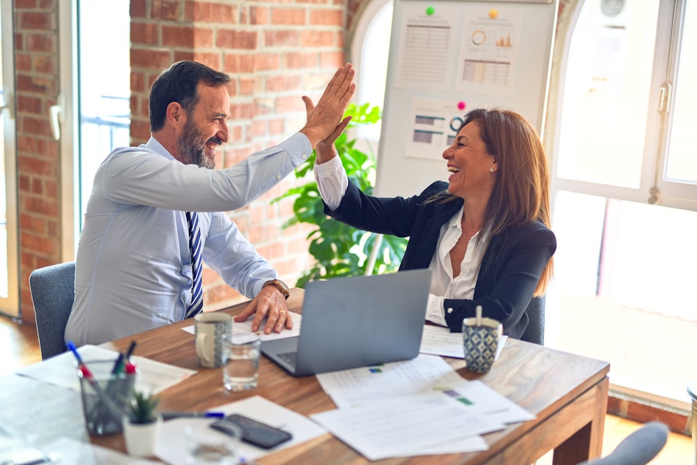 Two insurance professionals shaking hands in an office