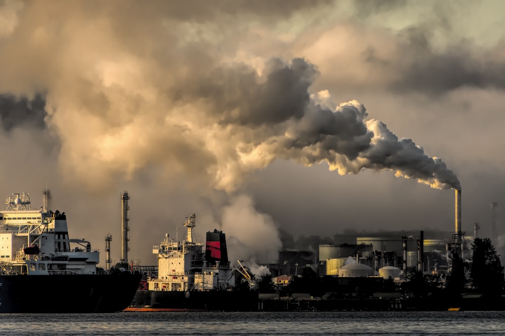 Industrial facility emitting airborne pollution over a waterfront